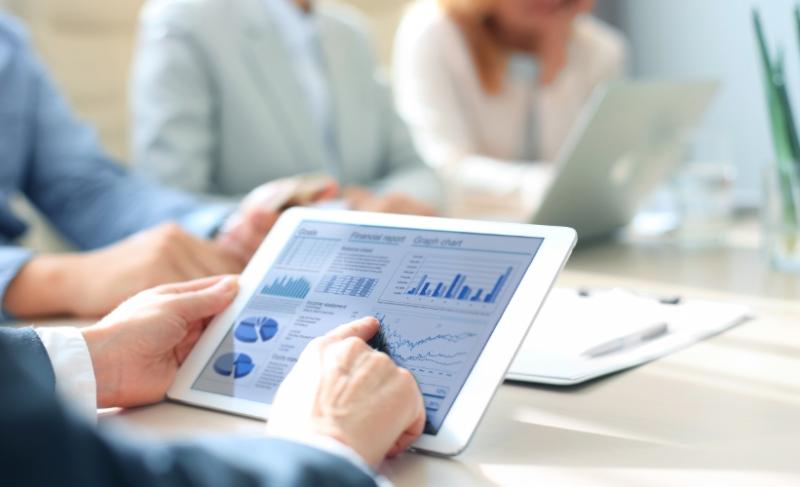 Financial professional looking at analytics and metrics on a tablet Financial professional looking at analytics and metrics on a tablet